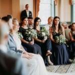 Bridesmaids sitting at wedding.