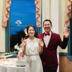 Guests posing by the cake and desserts.