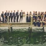 The wedding party posing on the dock.