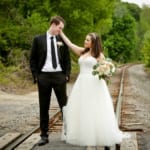 Lina and Matt playfully posing on train crossing.