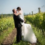 Melissa and Marcin embracing in the winery field.