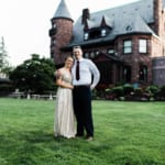 Groomsman and bridesmaid posing in front of Belhurst.