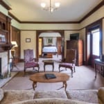 Couch, table, chairs and fireplace in living room of the Dwyer Suite.