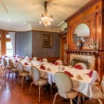 Tables set end-to-end for a large group in the Parlor at Edgar's Restaurant.