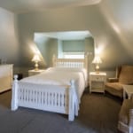 Bed and chairs in the Garrett Room at Belhurst Castle.