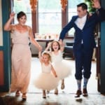 Bridesmaid and groomsman walking into the reception with the flower girls.