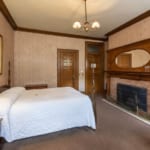Bed and fireplace in the Otis Room at Belhurst Castle.