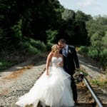 Shannon and Nick kissing on the railroad track.